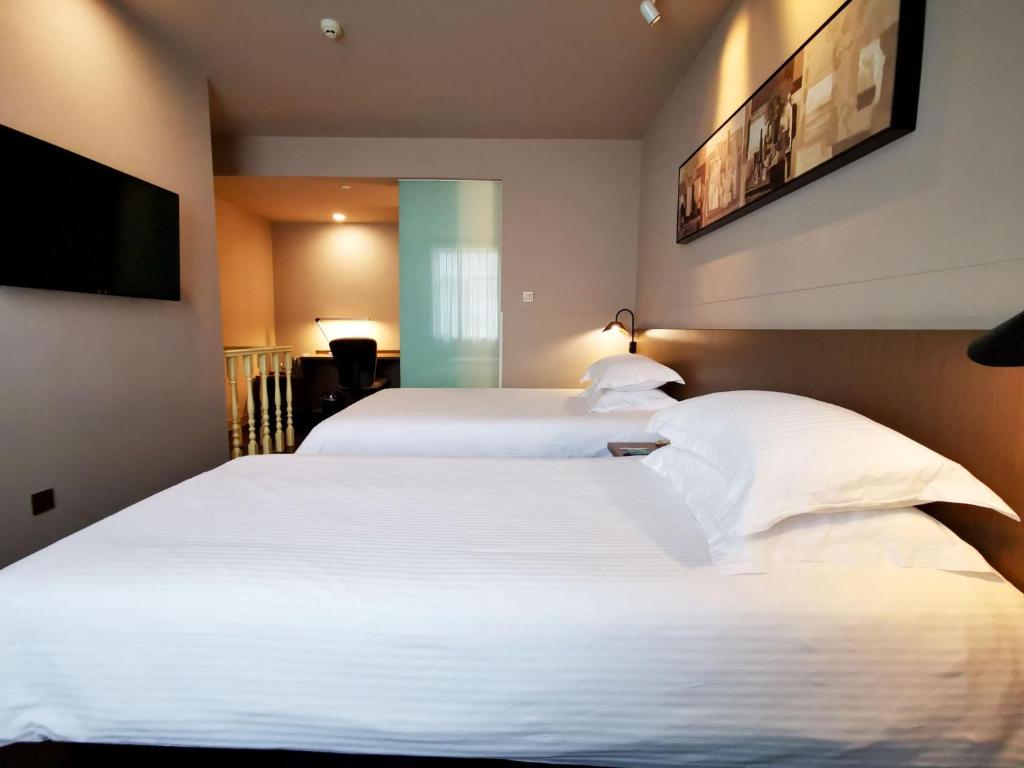 Säng eller sängar i ett rum på Jinjiang Inn select JiNing Qufu Scenic Region North Gulou Street, Jining