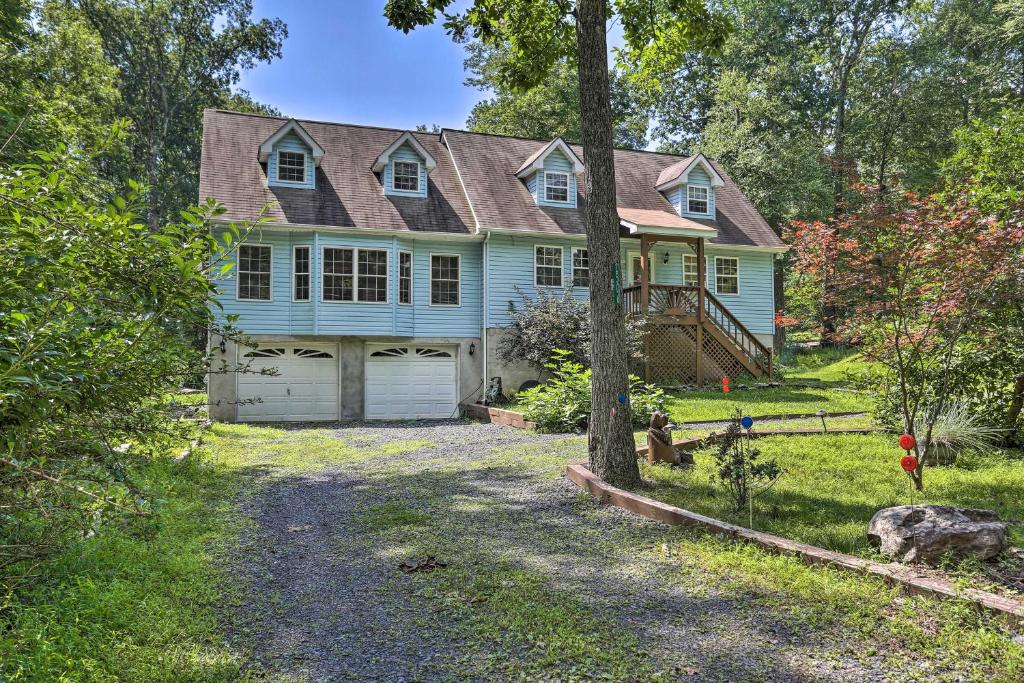 una casa blu con un garage nel cortile di 5 Mi to Camelback Henryville Home with Hot Tub! a Henryville