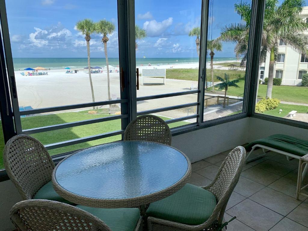 a table and chairs in a room with a view of the beach at Island House Beach Resort 4S in Point O'Rocks