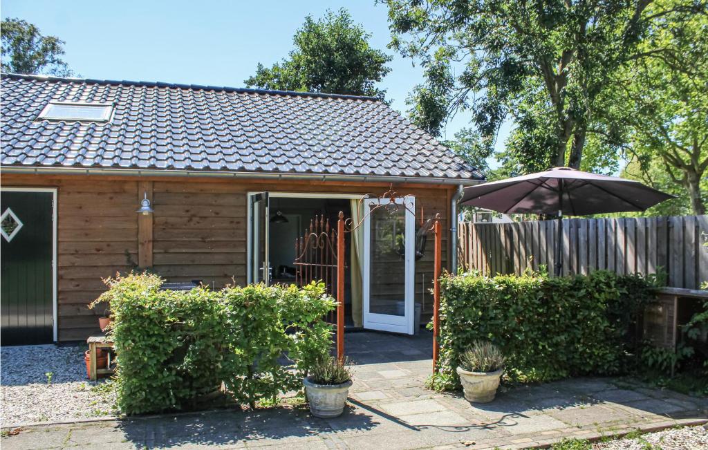 uma casa com um guarda-chuva e uma cerca em Voor Anker em Loosdrecht