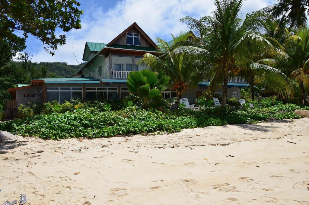 una casa en la playa con palmeras en Moonlight Beach Villa, en La Digue