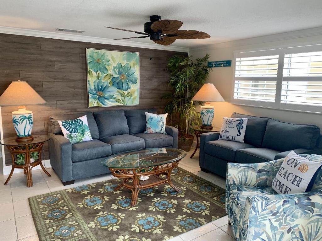 uma sala de estar com sofás azuis e uma mesa em Island House Beach Resort 36 em Point O'Rocks