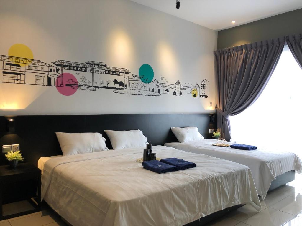 duas camas num quarto de hotel com toalhas em Aeropod Suites by Calvin em Kota Kinabalu
