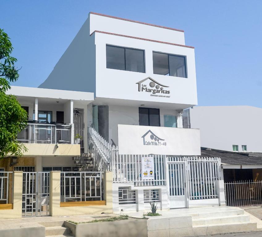 a large white building with a sign on it at Hotel Las Margaritas Alojamientos in Barranquilla