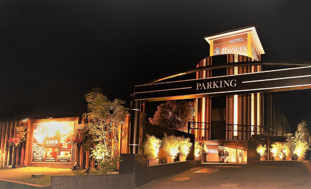 un edificio con un cartel de estacionamiento en él por la noche en Hotel Riviera Sagamihara (Adult Only), en Sagamihara