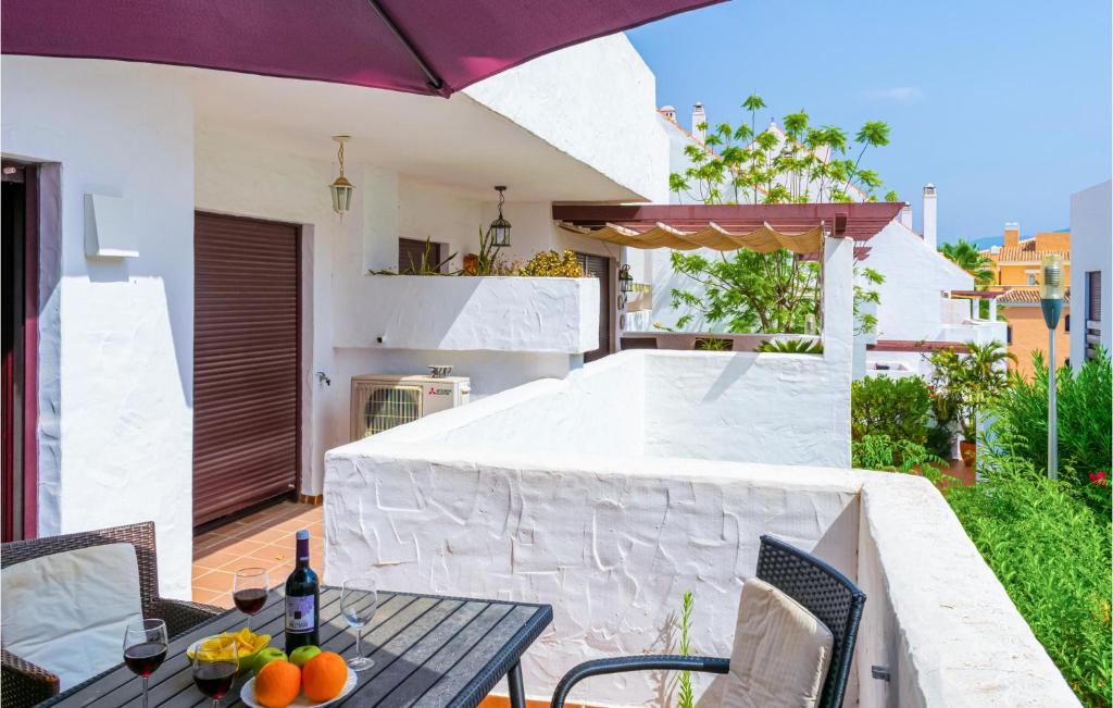 eine Terrasse mit einem Tisch, Stühlen und einem Sonnenschirm in der Unterkunft Stunning Apartment In Marbella With Wifi in Marbella