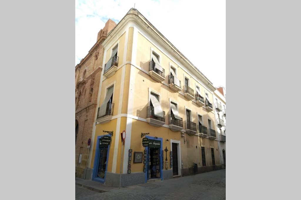ein gelbes Gebäude mit blauen Türen auf einer Straße in der Unterkunft Apartamento Centro Encarnación 1º D in Sevilla
