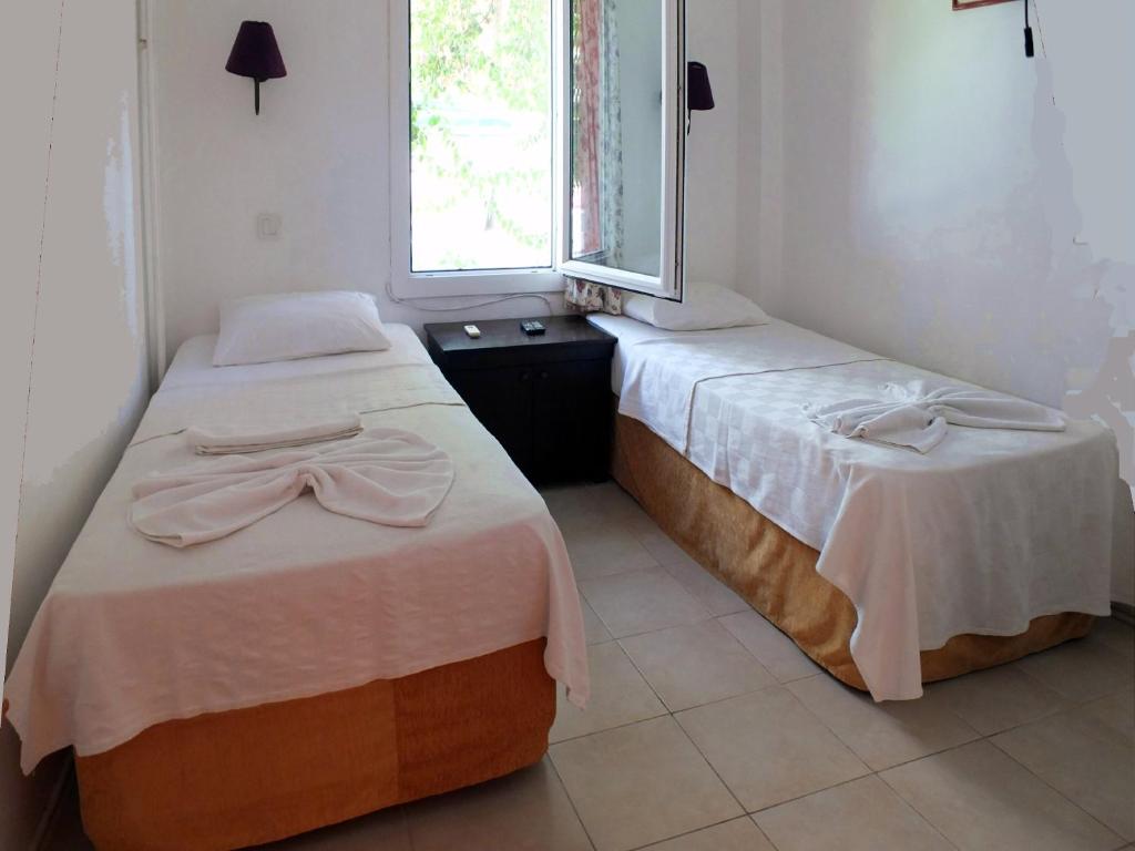 dos camas sentadas una al lado de la otra en una habitación en Bircan Hotel, en Bodrum City