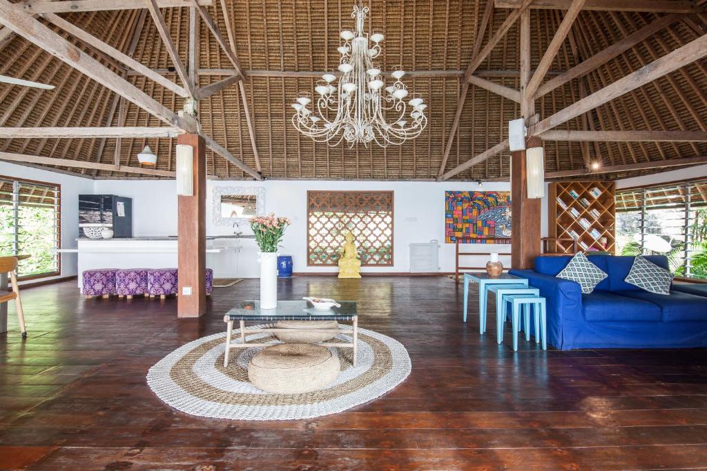 a large room with a chandelier and a table and chairs at Villa GMB Beach house in Uluwatu