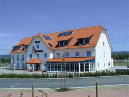 a large white building with an orange roof at Hotel Montana Lauenau in Lauenau