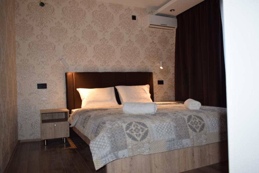 ein Schlafzimmer mit einem großen Bett mit weißer Bettwäsche und Kissen in der Unterkunft Hotel "Srbija Tis" in Zaječar