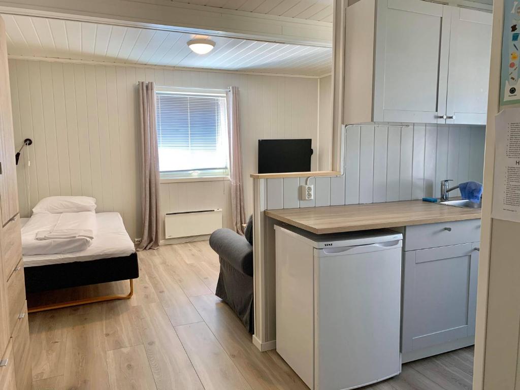 莫舍恩的住宿－Mosjøen Overnatting, Vollanvegen 13，一间小房间,设有厨房和一张床