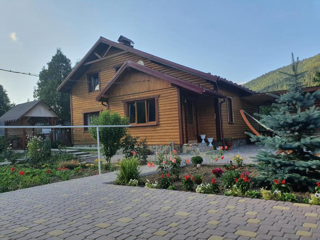 una casa de madera con un jardín frente a ella en Emiliya en Tatariv