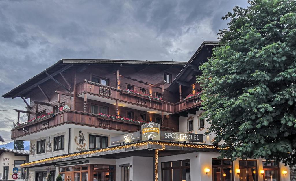 a large building with a balcony on top of it at SCOL Sporthotel Zillertal in Fügen