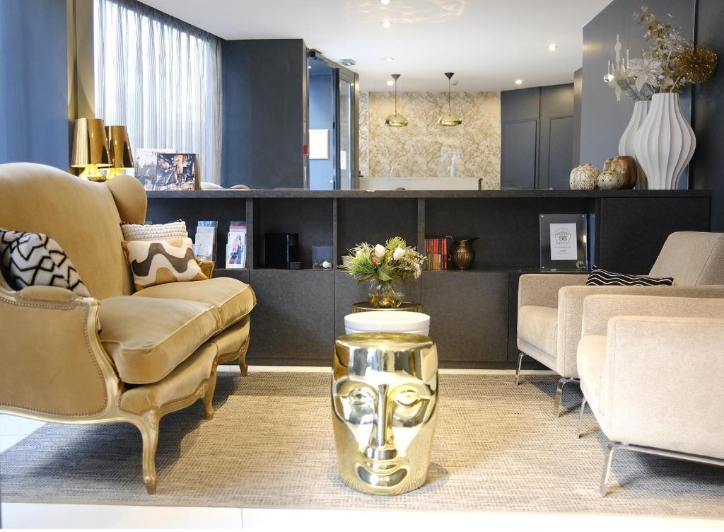 een woonkamer met een bank, stoelen en een tafel bij Villa des Ambassadeurs in Parijs