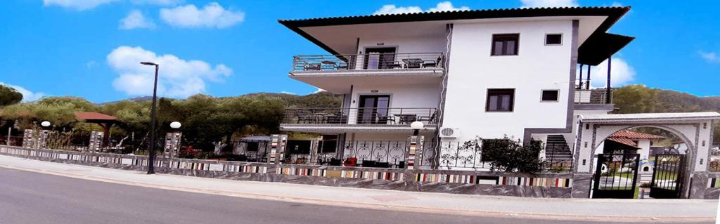 a white building on the side of a street at House Anna Houhlia in Vourvourou