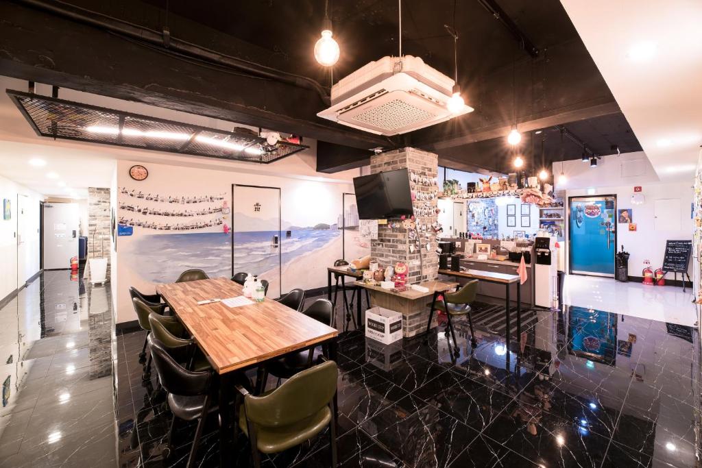 釜山的住宿－MAMA Guesthouse Haeundae，一间带桌椅的用餐室