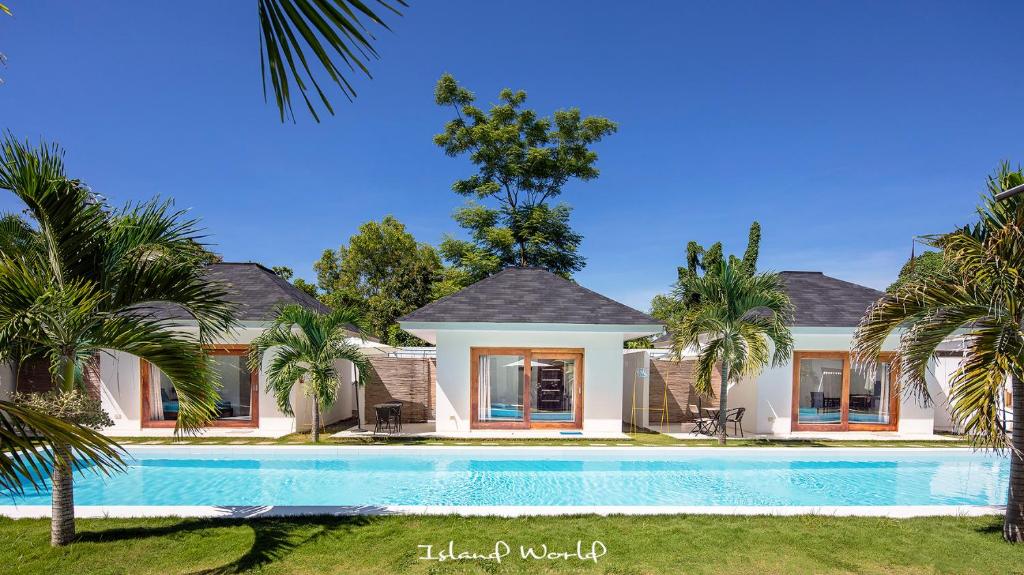 a house with a swimming pool and palm trees at Island World Panglao in Panglao