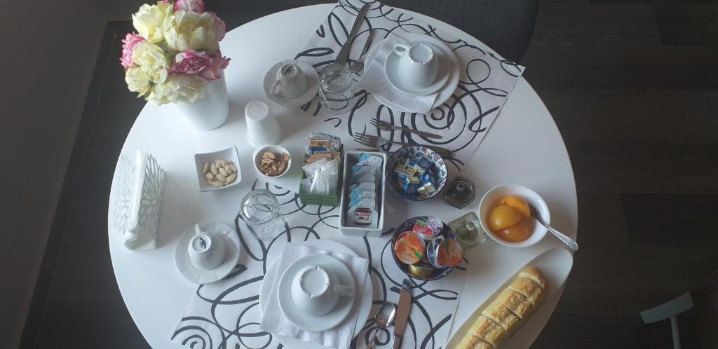 stół z białym talerzem z jedzeniem i kwiatami w obiekcie B&B Grazia w mieście Kapua