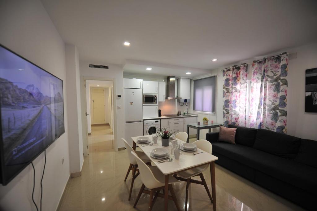 a living room with a couch and a table and chairs at Centrico Playa Caleta 3 dormitorios in Cádiz