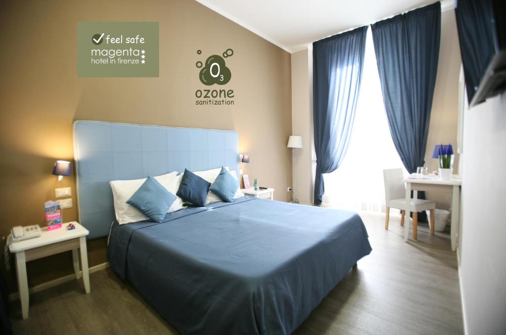 フィレンツェにあるホテル マジェンタのベッドルーム1室(青いベッド1台、青いシーツ付)