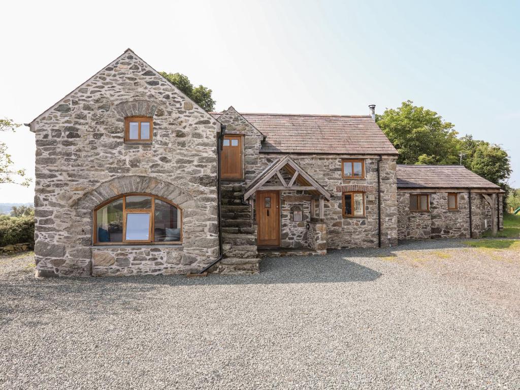 a large stone house with a stone driveway at Ty Cerrig in Gaerwen