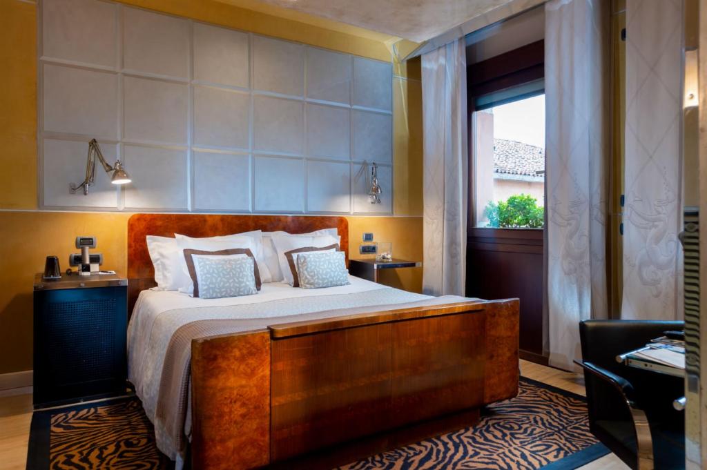 a bedroom with a large bed and a window at Ca' Pisani Hotel in Venice