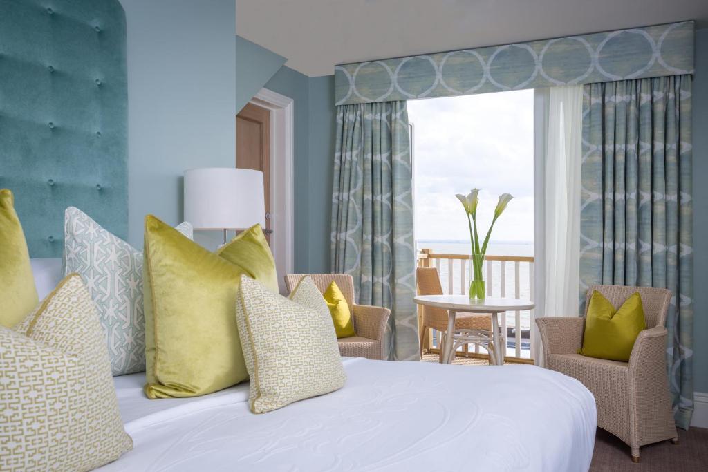 a bedroom with a white bed with yellow pillows at Roslin Beach Hotel in Southend-on-Sea