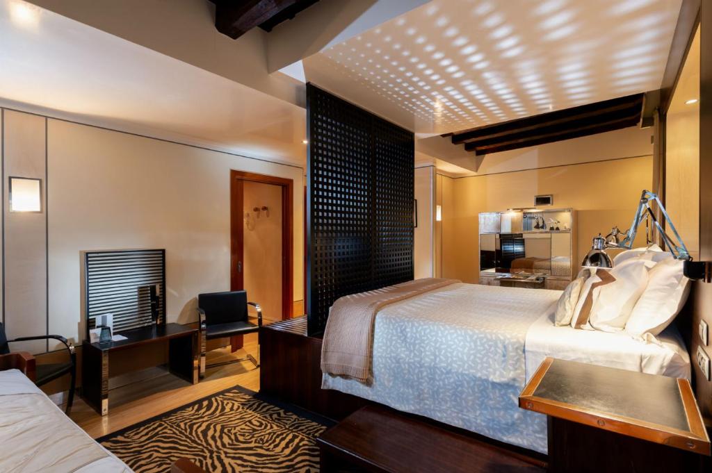 a hotel room with two beds and a desk at Ca' Pisani Hotel in Venice