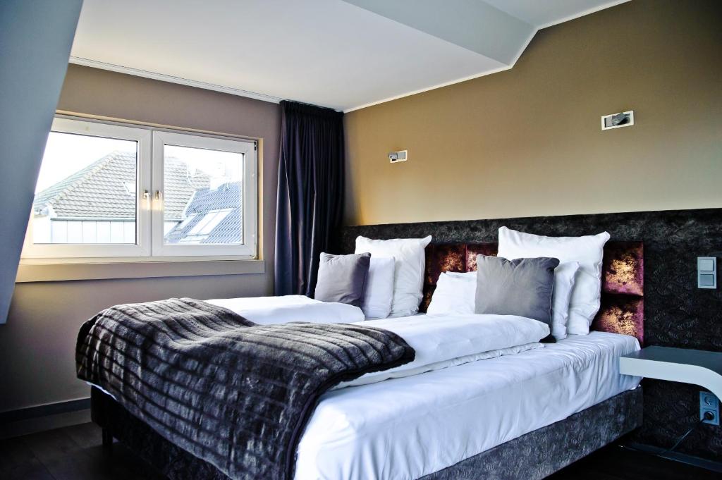 a hotel room with two beds and a window at Hotel Rosenmeer in Mönchengladbach