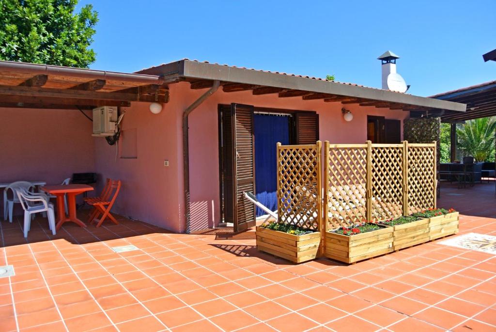 ein Haus mit einer Terrasse mit einem Tisch und Stühlen in der Unterkunft Bilocale in Villa Elba in Marina di Campo