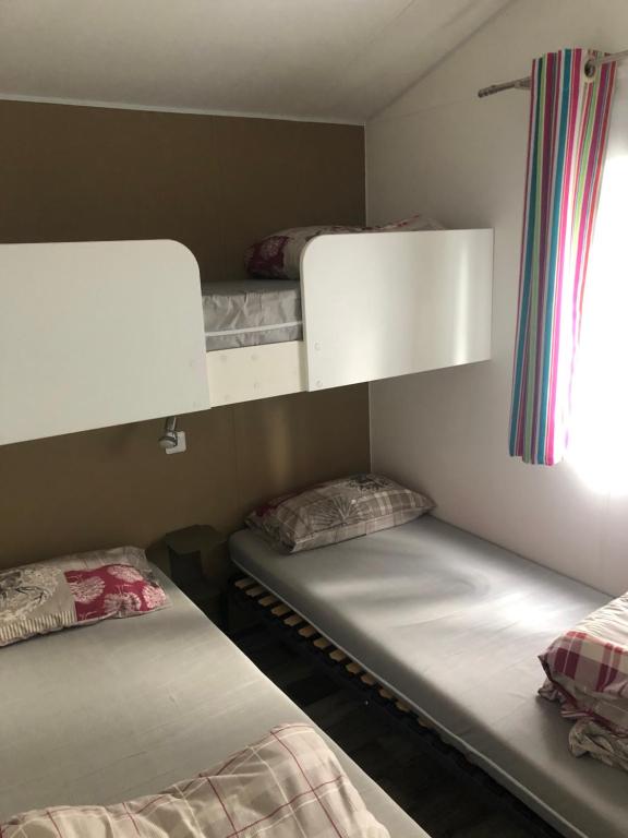 a room with two bunk beds and a window at Mobile Homes by KelAir at Camping L'Hippocampe in Argelès-sur-Mer