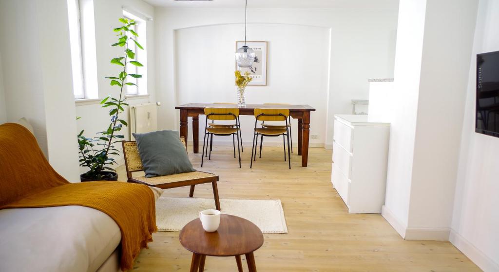a living room with a table and chairs and a dining room at Bright apartment next to the King's Garden in Copenhagen