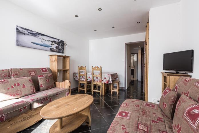 a living room with a couch and a table at Studio 4 personnes au pied des pistes in Tignes