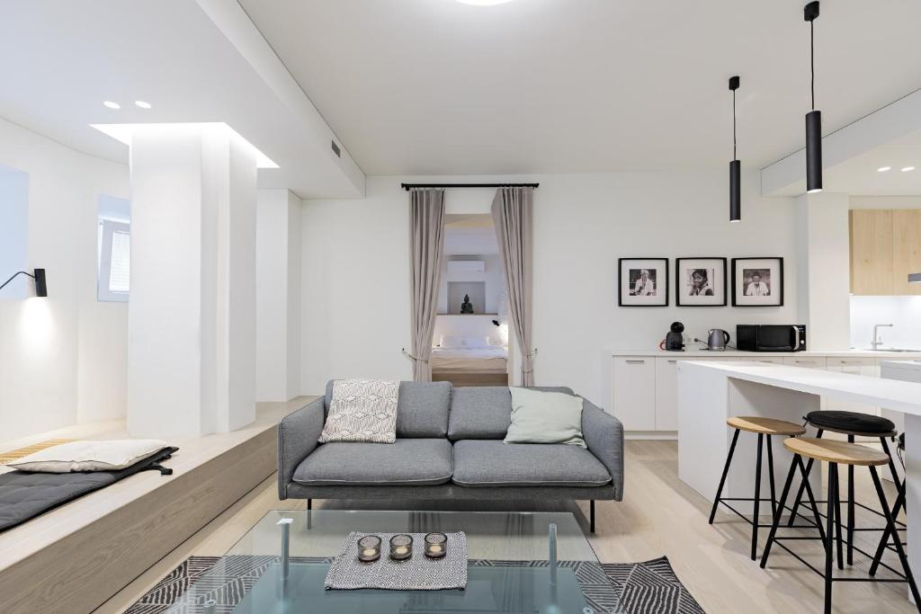 ein Wohnzimmer mit einem Sofa und einer Küche in der Unterkunft Buddha Luxury Apartment Kaunas city centre in Kaunas