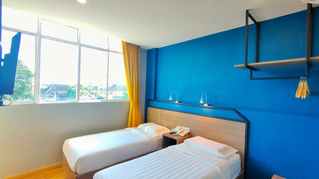 Postel nebo postele na pokoji v ubytování Uptown Hotel