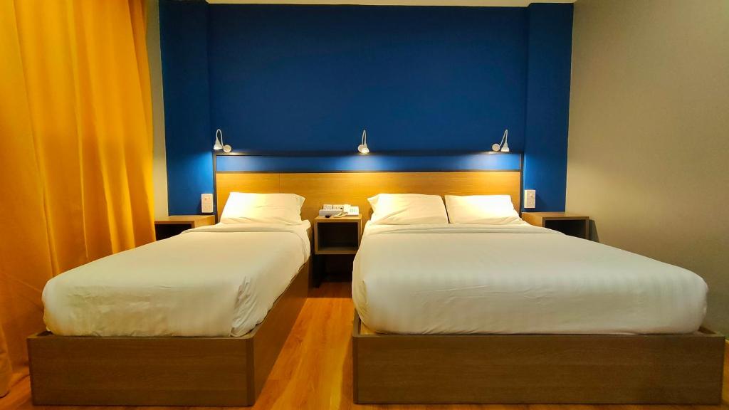 Postel nebo postele na pokoji v ubytování Uptown Hotel