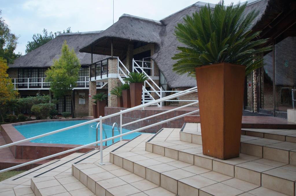 a villa with a swimming pool and a house at The Waterfront Country Lodge in Vaalview