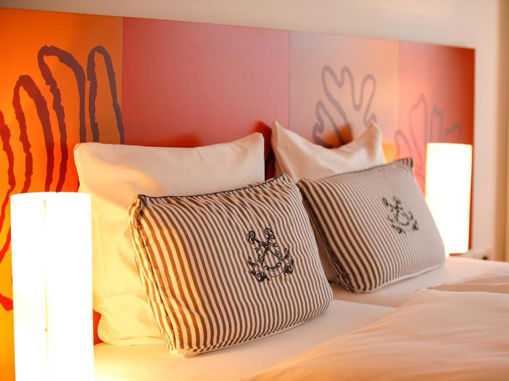 a bed with several pillows on top of it at Hotel Begardenhof in Cologne