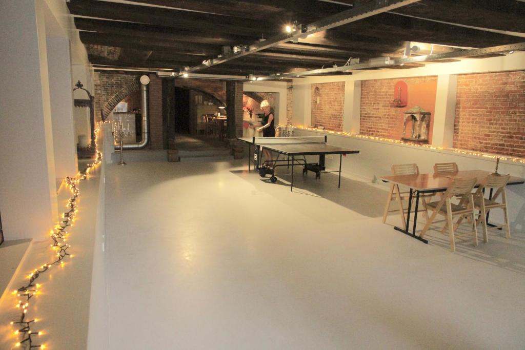 a room with tables and chairs and lights on the floor at Top apartment along canal in historic centre in Amsterdam