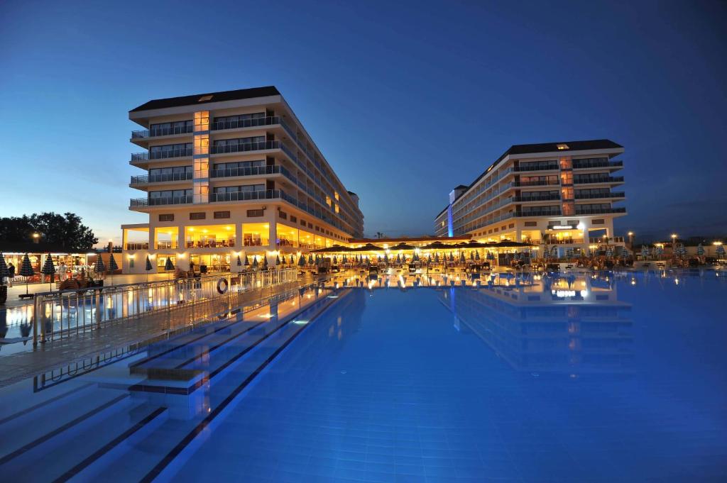 un edificio con piscina frente a un edificio en Eftalia Aqua Resort, en Konaklı