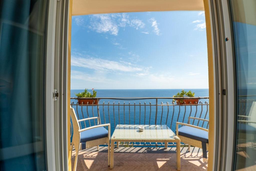 a balcony with a table and chairs and the ocean at Hotel Villa Pandora in Maiori