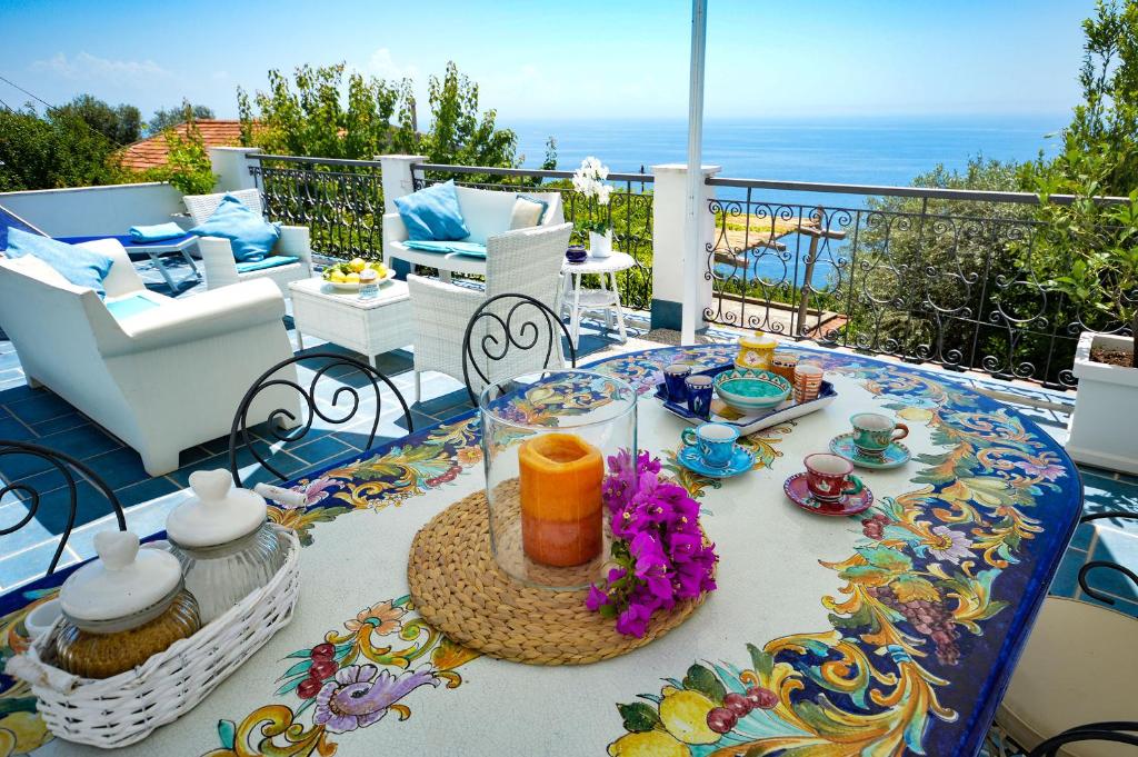 a patio with a table and chairs on a balcony at Villa Azzurra in Conca dei Marini