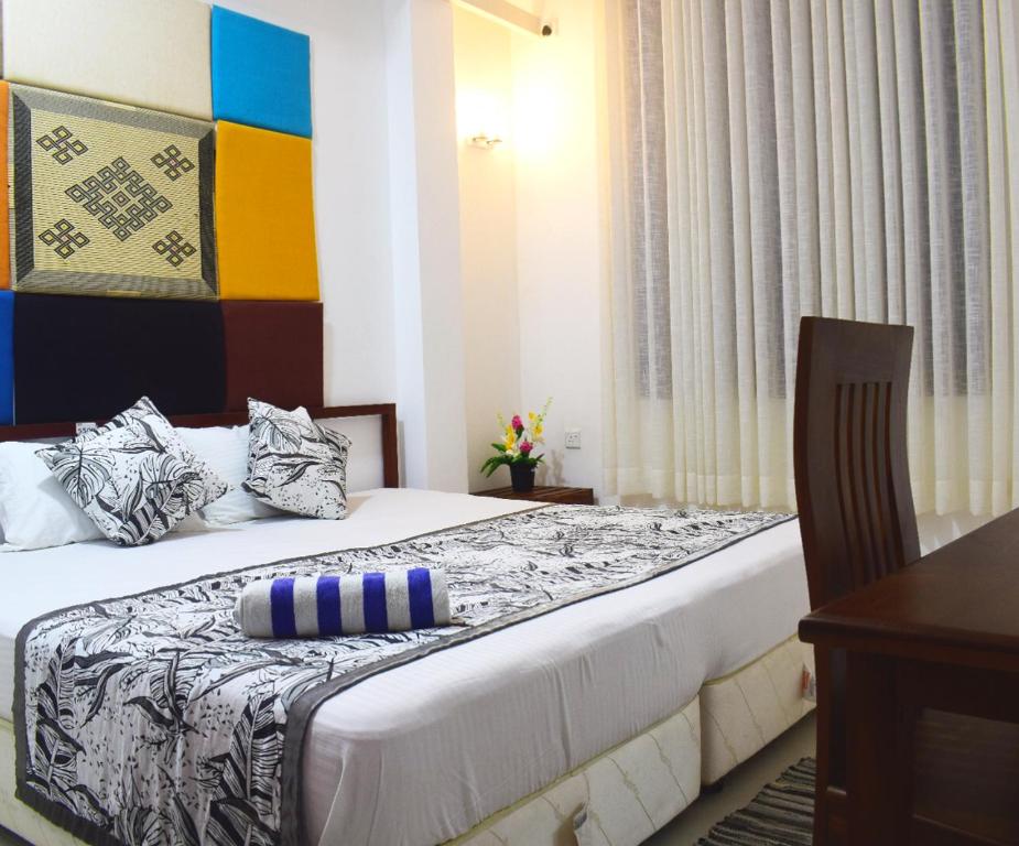 a hotel room with a bed with a pillow on it at White Fortress in Sri Jayewardenepura Kotte