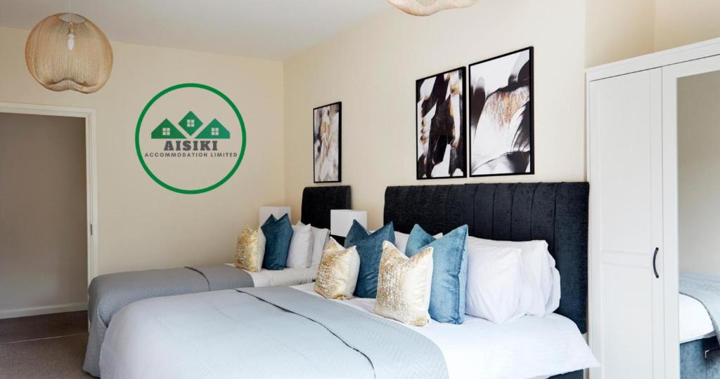 um quarto com uma cama com almofadas azuis e brancas em Aisiki Living at Alexandra Road, 2 Bedrooms and 2 Bathrooms with King or Twin beds and with FREE WIFI and PARKING em Watford