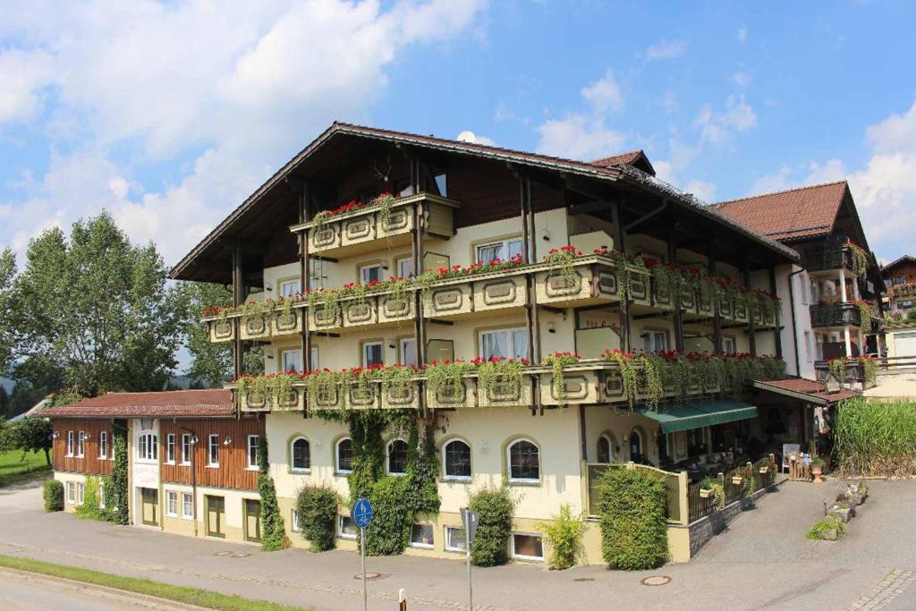 un grande edificio con balconi e fiori di Zum singenden Musikantenwirt a Regen