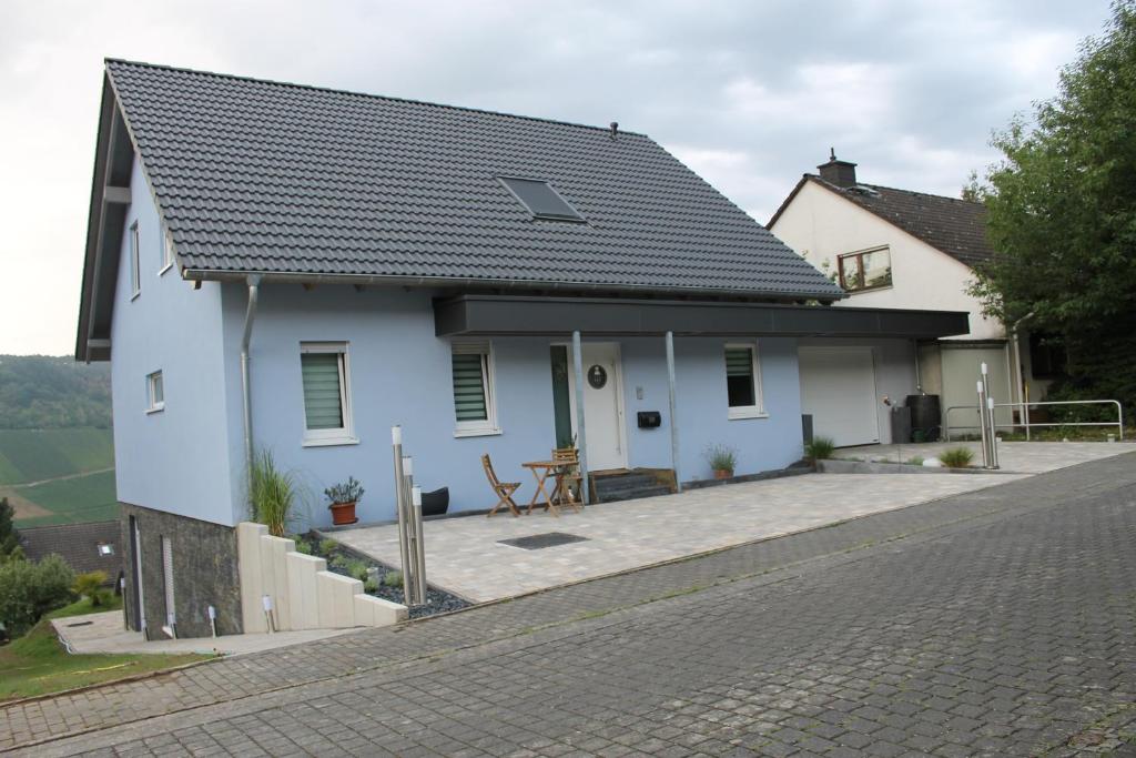 a white house with a patio and a table at Ferienwohnung Moselpanorama in Traben-Trarbach