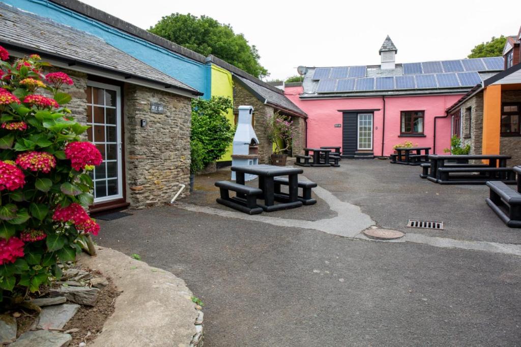 a patio with a picnic table in front of some buildings at Yetland Farm Holiday Cottages in Combe Martin