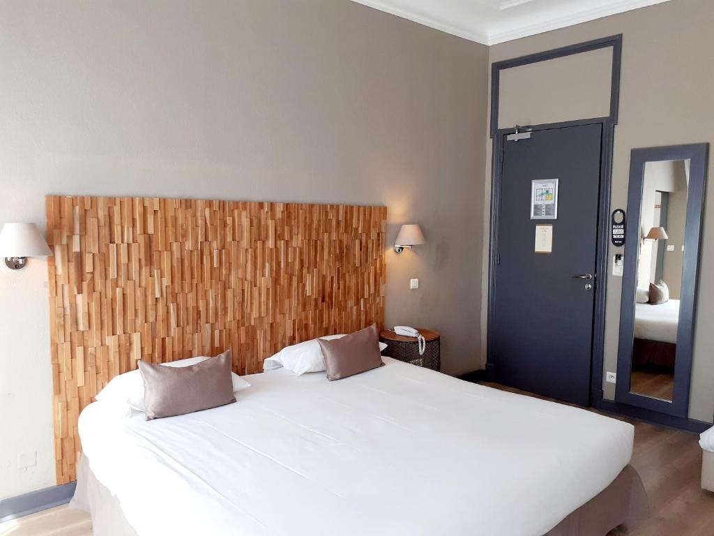 a bedroom with a large white bed and a mirror at Hôtel La Villa Tosca in Cannes