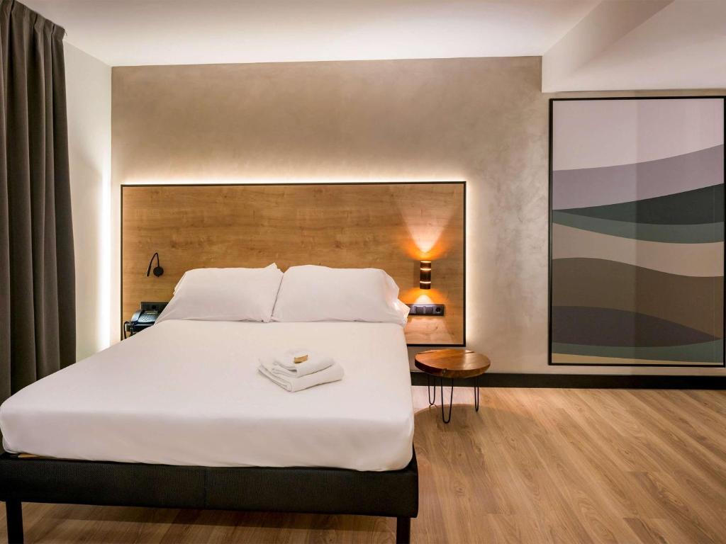 a bedroom with a large bed and a large picture at Ibis Styles Figueres Ronda in Figueres